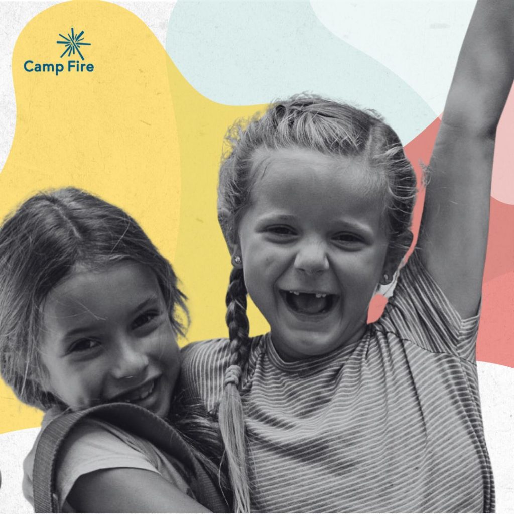 Two young girls standing in front of a pink, blue, and yellow background.